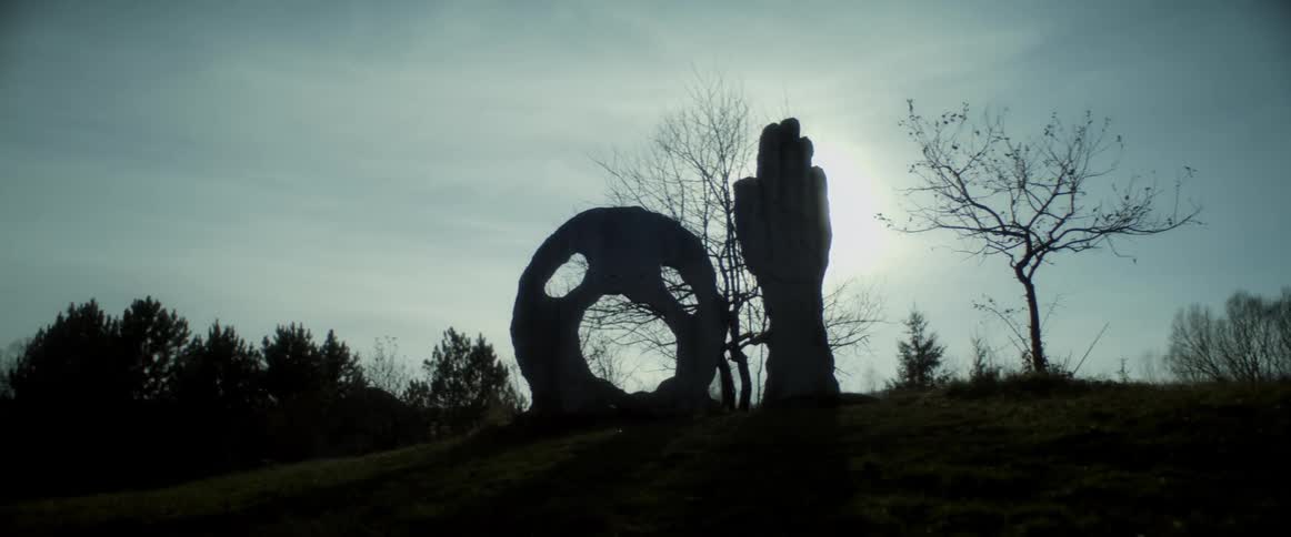 A spooky statue of a face is on the hill