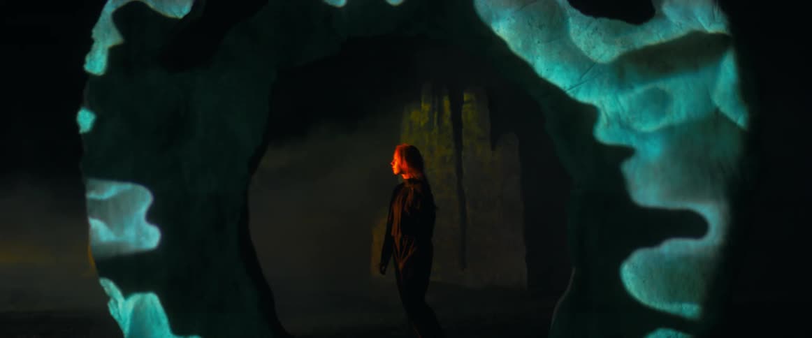 A person is standing in a dark lit room at night