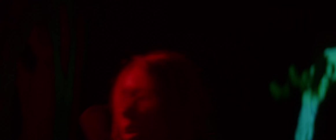 A woman is dancing outdoors during the night time