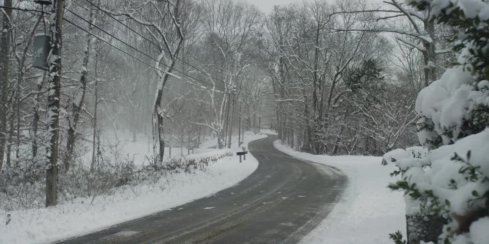 Snow is covering the rural area and street