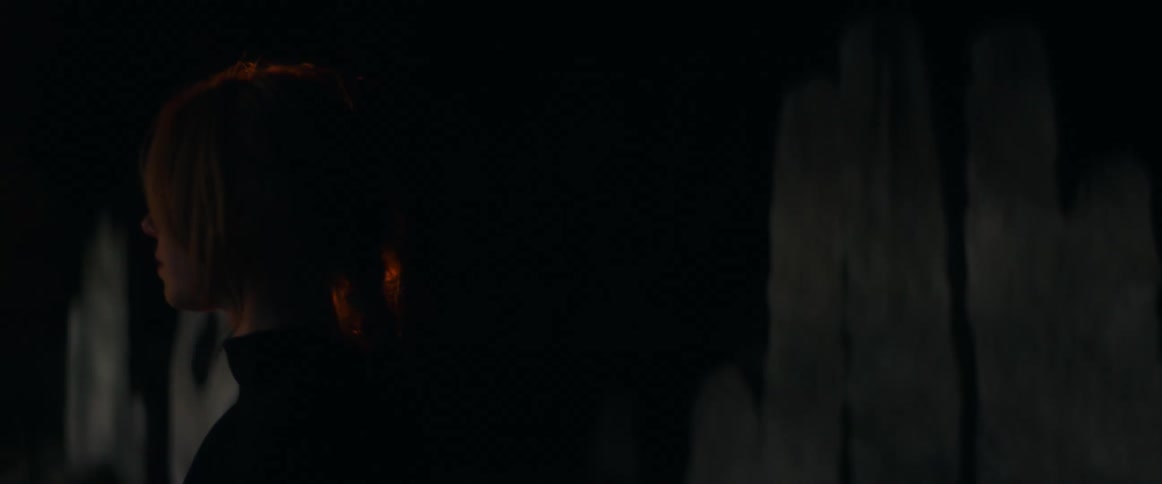 A woman is walking around a room at night