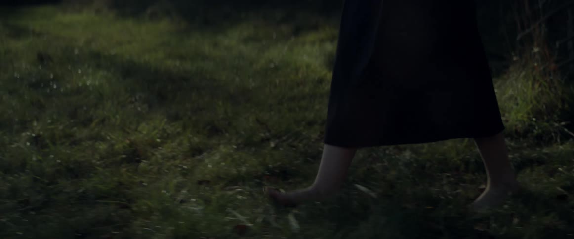 A woman walking outdoors in a forest area
