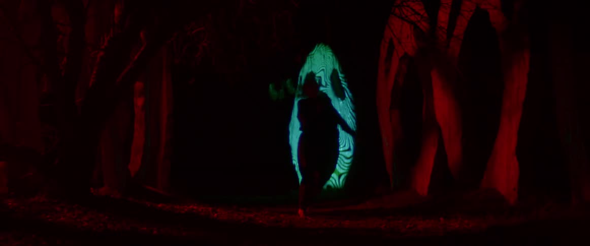 A woman is dancing by the scary sculptures
