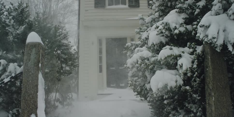 A snow storm is forming in a neighborhood with houses