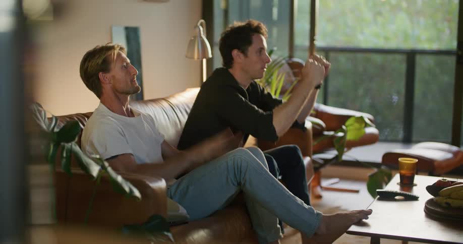 Two friends are celebrating together and sitting on a couch