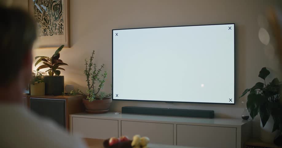 A man is watching television in a living room