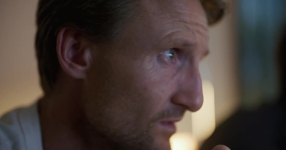 Two men are watching television together in a living room