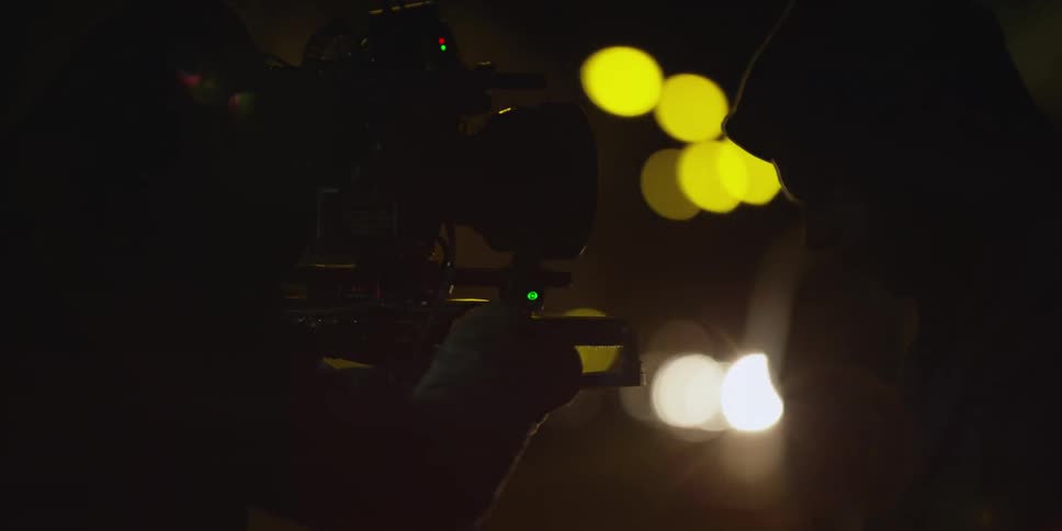 People are operating a camera at night