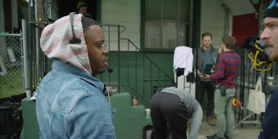 A film crew is in front of a home as people exit