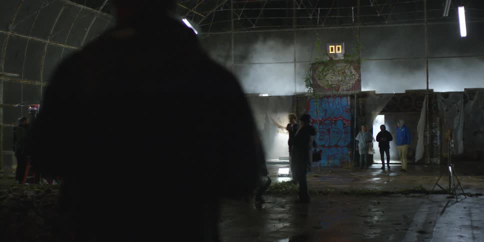 A group of people are on a basketball court at night