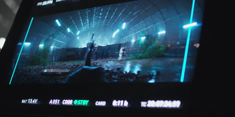 A video display shows a man turning