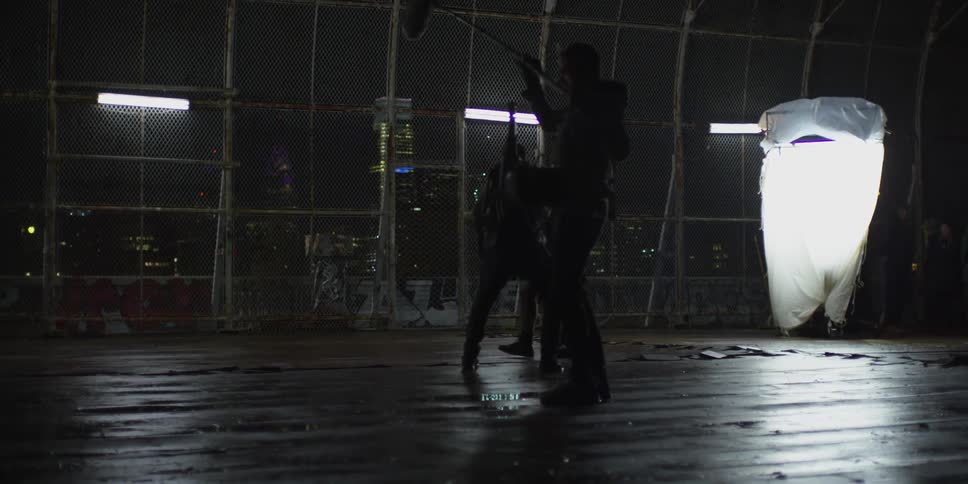 A boy is playing basketball in front of some cameras