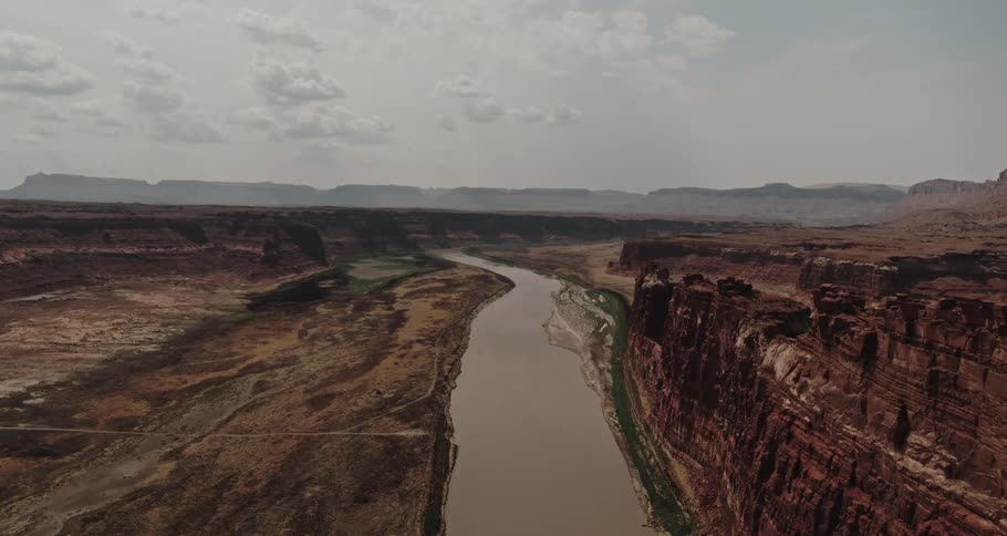 River runs through canyon and toward misty mountains on the horizon