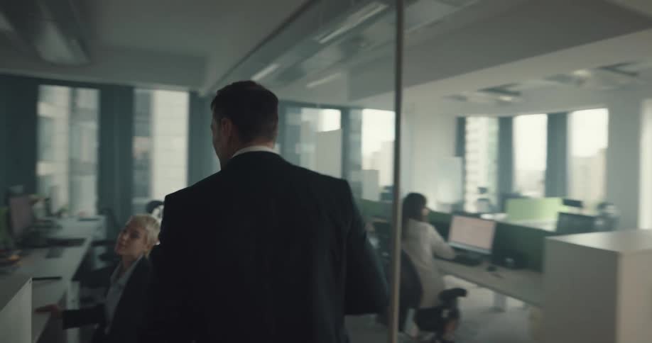 Boss enters the office and stands close to a worker to check her work