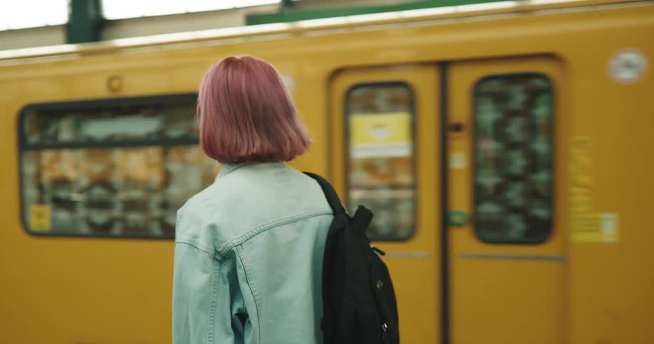 Waiting woman walks toward opening door on newly arrived train in transit station