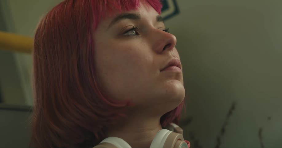 A teenager is sitting with a pair of headphones