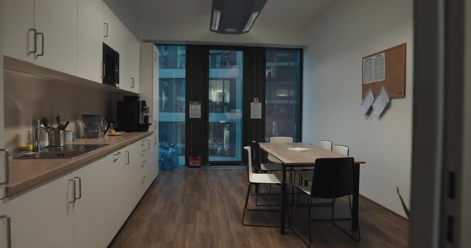 Long table sits in kitchen net to cork bulletin board