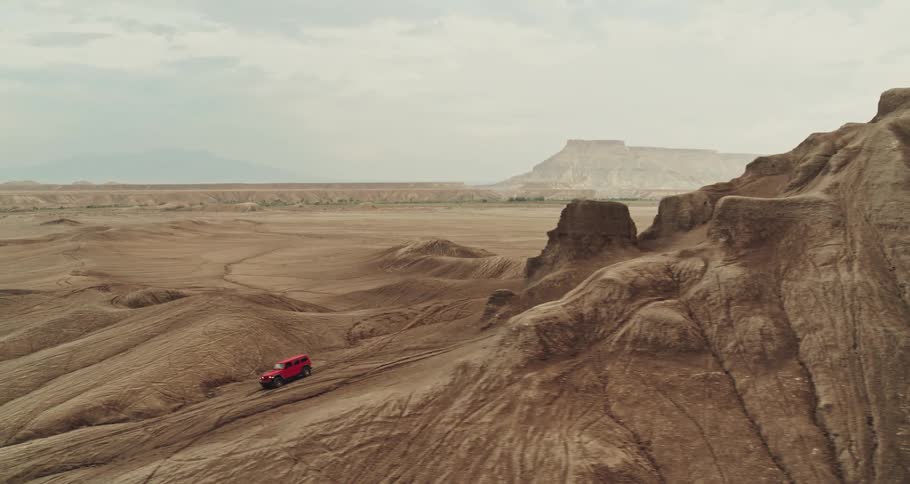 A car is driving off road through a valley