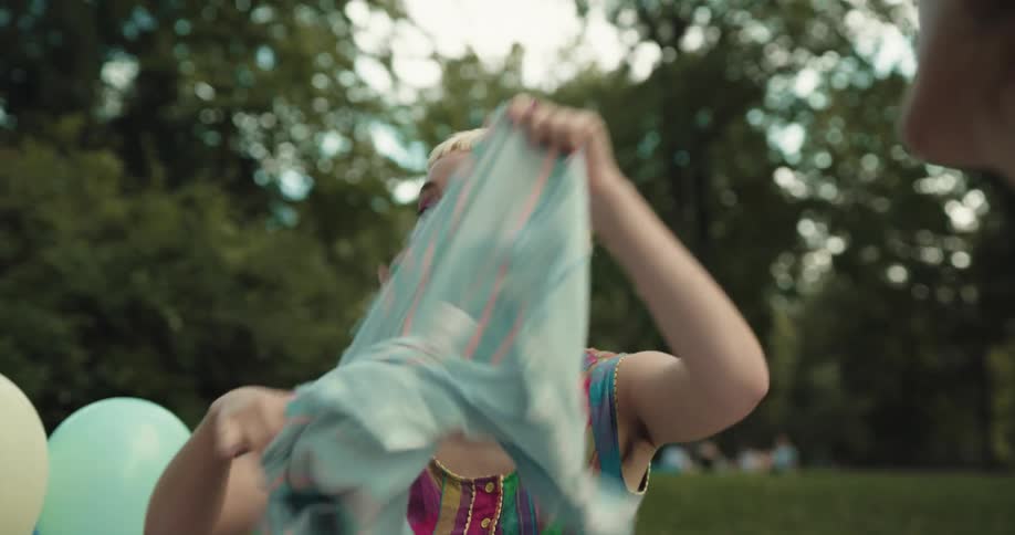 A woman wraps a shawl around her after opening a birthday gift bag