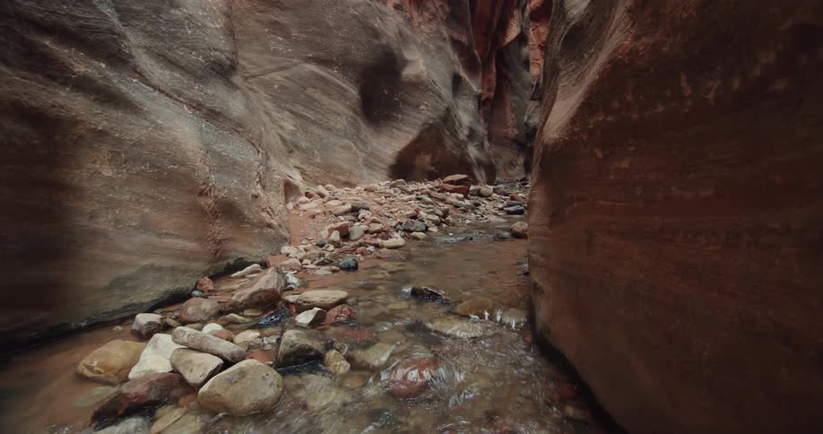 River water flows over stones and through canyon
