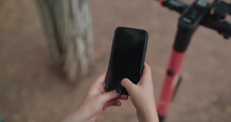A person is texting on their cell phone outdoors