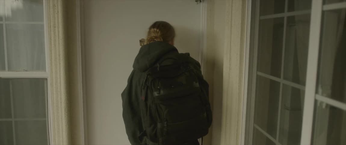 A man is leaving his house and carrying a backpack