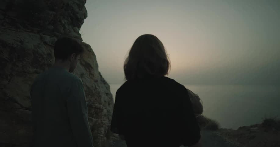 A man and woman walking at the beach