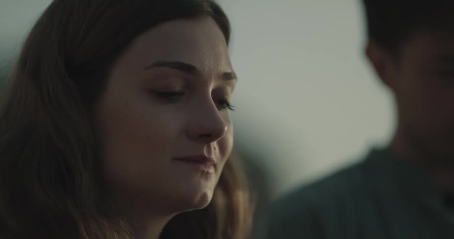 A man and woman meditate outside with their eyes closed and heads bowed