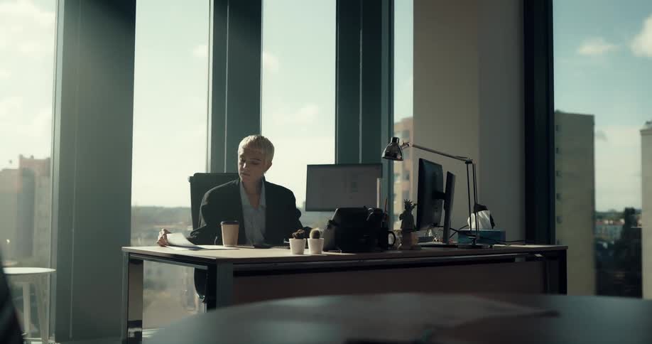An employee is working in her office at dusk