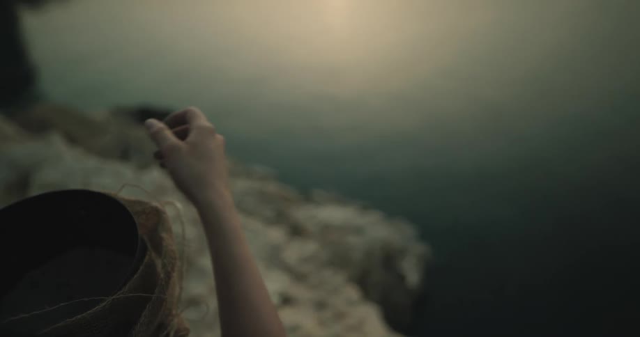 Woman spreads ashes as water reflects sun