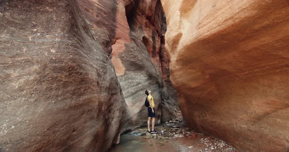 A man is hiking between a rock formation