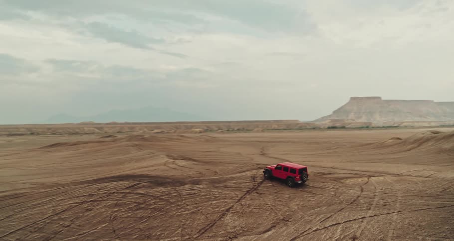 A sport utility vehicle drives through a vast desert