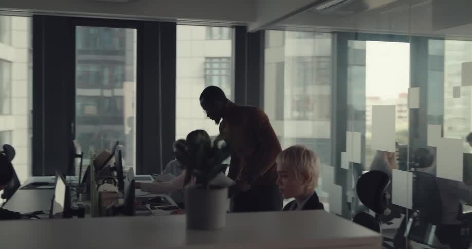 Boss reviews papers then throws them into the air and walks away as employees continue to work