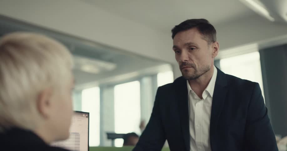 Coworkers discussing about work in front of a computer in the office