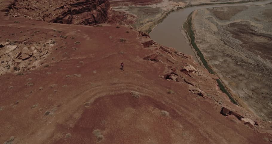 Aerial view of a person hiking across a mountainous landscape