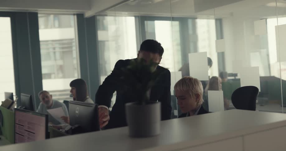 A man throws papers and yells as his employee in the office