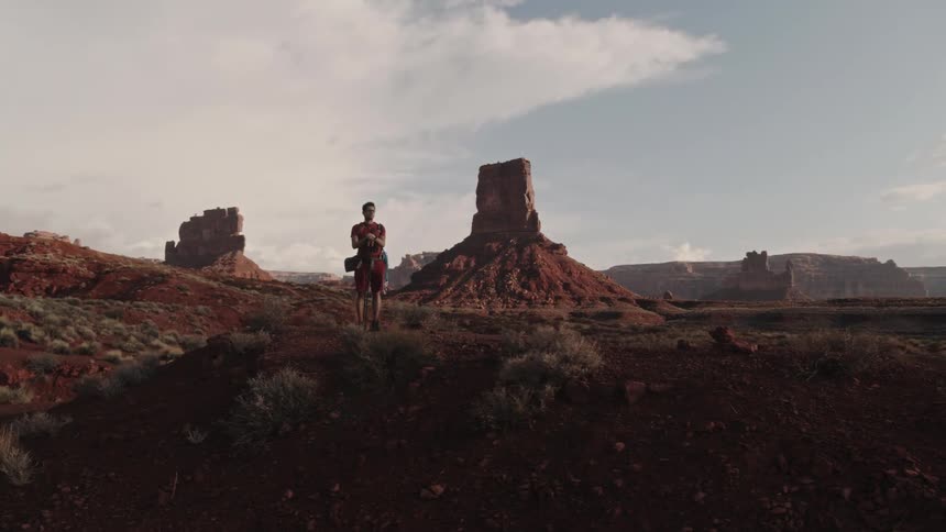 A man standing out in the desert on a hike