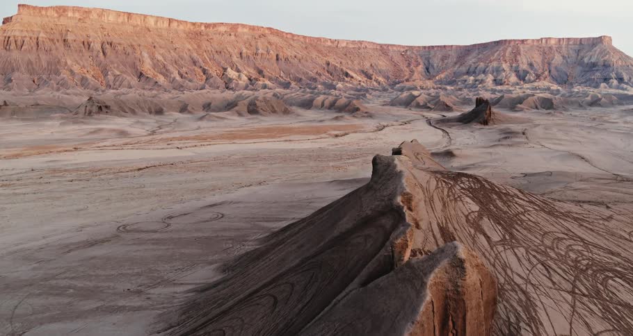 Lowridge sits in desert with plateau in the distance
