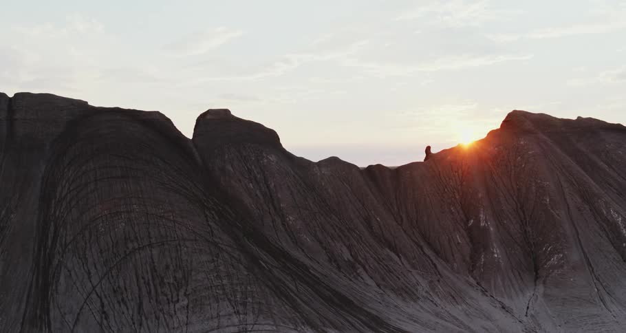 The sun is peeking over the steep mountain peaks
