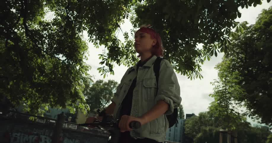 A woman rides a scooter in a park