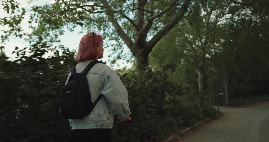 A girl is riding a scooter in a public park