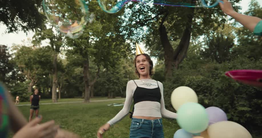 A group of women celebrate outside with balloons and large bubbles