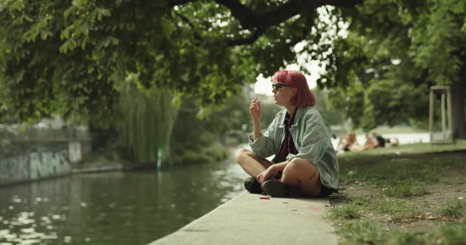 A woman smokes near the canal