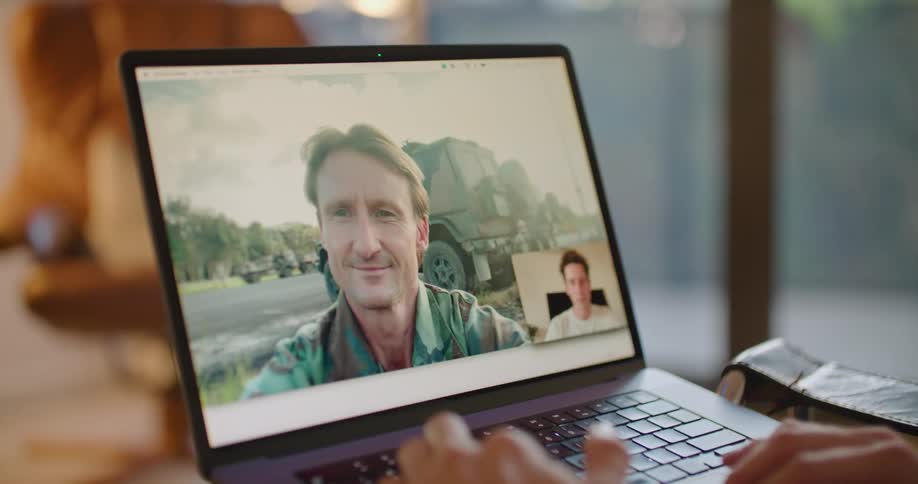 A man is having a video conversation with another man on a laptop computer