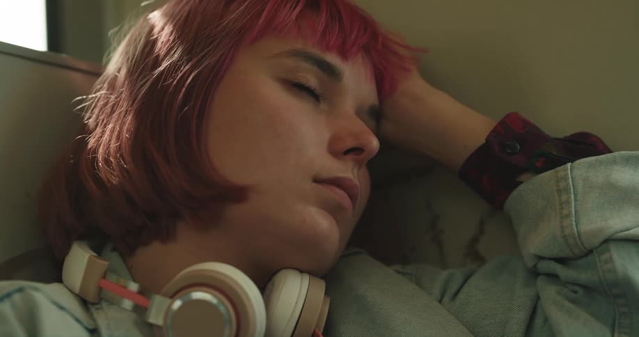 A girl is resting while being a passenger in a vehicle
