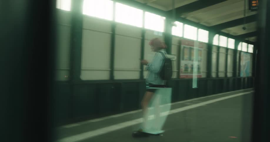 A woman is standing on a train platform waiting for a train