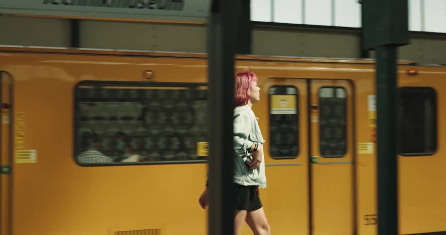 A woman exits a train car in a train station
