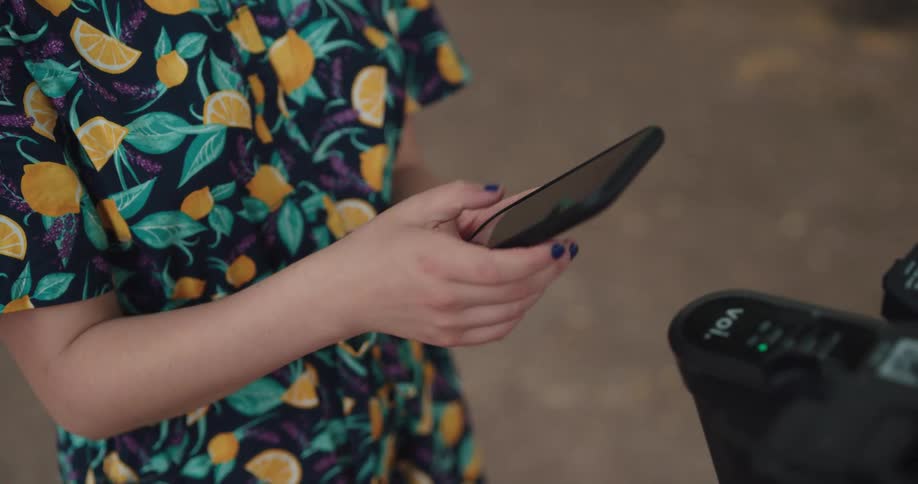 A woman is outside texting on her cellphone