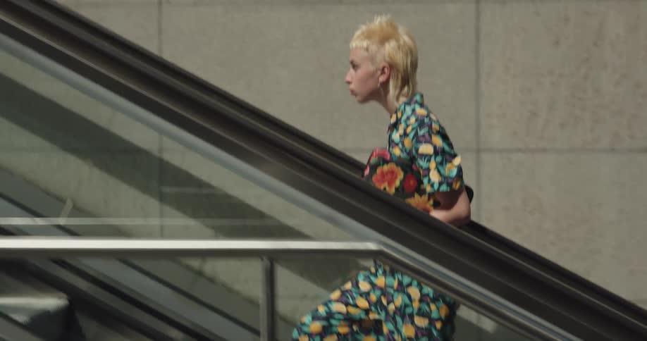 A woman is walking through a building in a downtown city