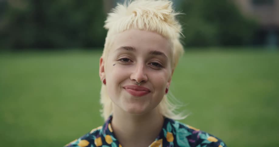 A portrait view of a woman smiling outdoors is displayed